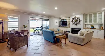 a living room with a couch and chairs and a table at Skye Cottage in Onrus River in Hermanus