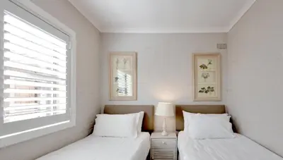 two beds in a white room with a window at Skye Cottage in Onrus River in Hermanus