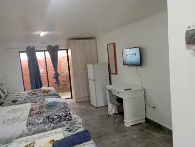 a room with two beds and a desk and a television at 8 Botha Goodwood the trout lodge in Elsiesrivier