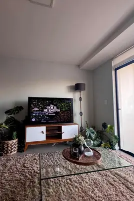 a living room with a large flat screen tv at Cosy Flat Steps from the Beach in Cape Town