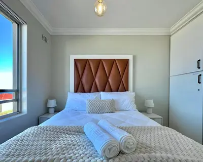 a bedroom with a large bed with two pillows on it at Ocean View in Hermanus