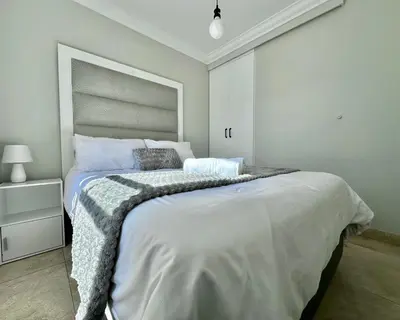 a white bedroom with a large bed in it at Ocean View in Hermanus