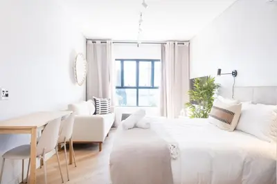 a white room with a bed and a table and chairs at Paarl Superior Studio 230 With Onsite Parking in Paarl