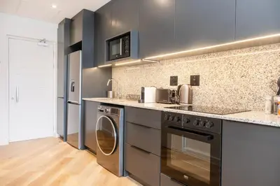 a kitchen with a washer and dryer at Paarl Superior Studio 230 With Onsite Parking in Paarl