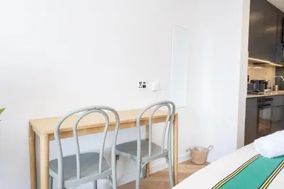 a kitchen with a wooden table and two chairs at Paarl Superior Studio 231 - With Onsite Parking & Comforts in Paarl