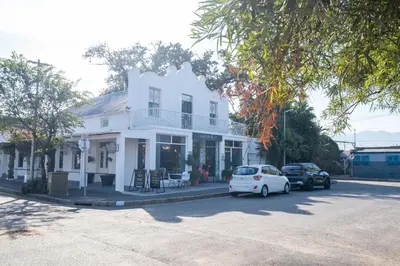 a white house with cars parked in front of it at Paarl Superior Studio 231 - With Onsite Parking & Comforts in Paarl