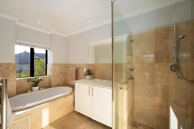 a bathroom with a tub and a sink and a shower at Modern Family Golf Lodge in Winelands Paradise in Paarl