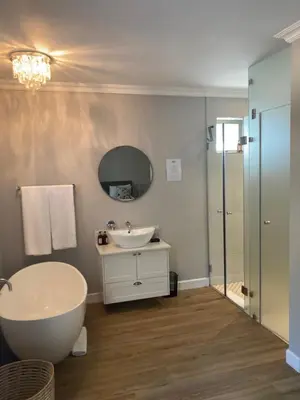 a bathroom with a tub and a sink and a mirror at Villa 121 Franschhoek Lermitage in Franschhoek