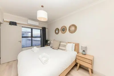 a bedroom with a large white bed and a window at Cape On Viola 13-Blouberg Gem Walk to Kite Beach & Ocean Views in Cape Town