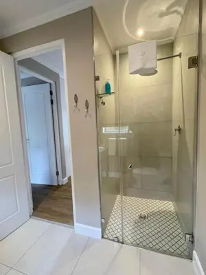a bathroom with a shower with a glass door at Villa Mignon in Franschhoek