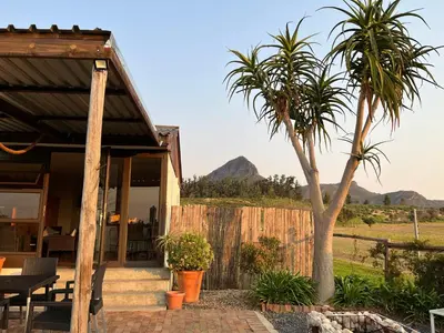 a house with two palm trees in front of it at Leliefontein Eco Cottage and Glamping in Paarl