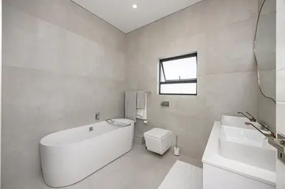 a white bathroom with a tub and a sink at Cape Town Bliss in Sandown in Cape Town