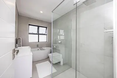 a bathroom with a shower and a toilet and a sink at Cape Town Bliss in Sandown in Cape Town
