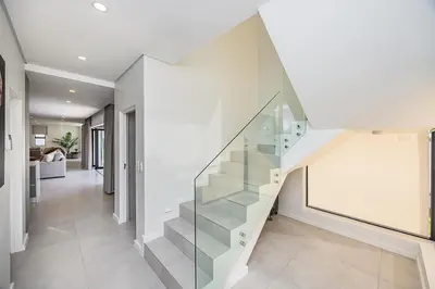 a staircase in a house with a glass wall at Cape Town Bliss in Sandown in Cape Town