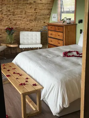 a bedroom with a bed with roses on a table at La Vita Romantic Getaway Cabin in Wellington