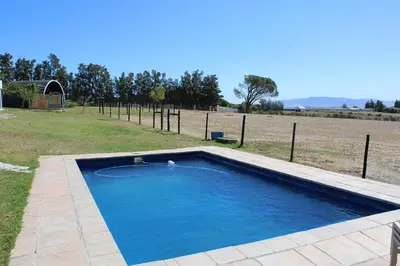 a swimming pool in the middle of a field at La Vita Romantic Getaway Cabin in Wellington