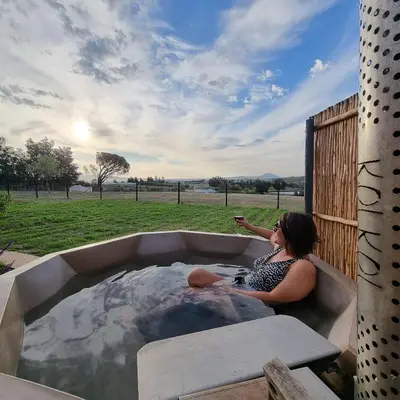 a woman is sitting in a hot tub at La Vita Romantic Getaway Cabin in Wellington