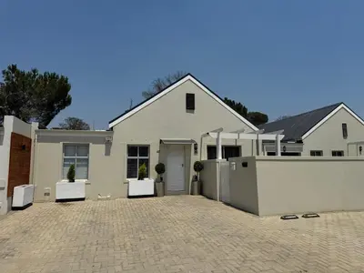 a white house with a fence and a driveway at Avalon 4 Bed 4 Bath House in residential security Estate in Stellenbosch