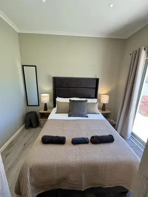 a bedroom with a large bed with two pillows on it at Avalon 4 Bed 4 Bath House in residential security Estate in Stellenbosch