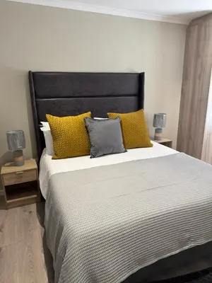 a bedroom with a large bed with yellow pillows at Avalon 4 Bed 4 Bath House in residential security Estate in Stellenbosch