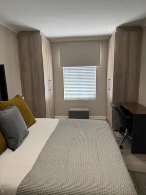 a bedroom with a bed and a desk and a window at Avalon 4 Bed 4 Bath House in residential security Estate in Stellenbosch