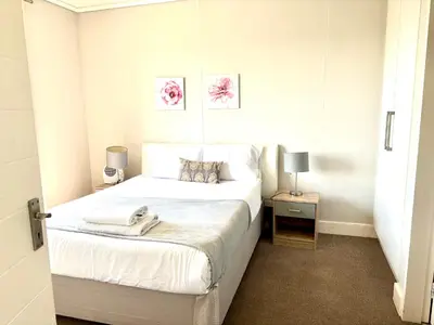 a bedroom with a large white bed and two lamps at Luxe watersedge apartment in Cape Town