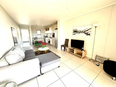 a living room with a couch and a tv at Luxe watersedge apartment in Cape Town