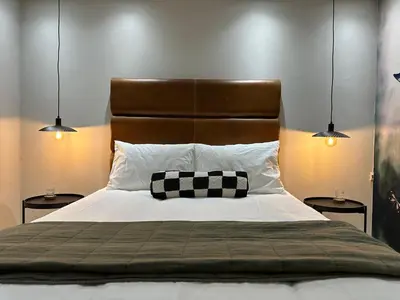 a bed with a black and white pillow and two lamps at 109 on Oudehoek in Stellenbosch
