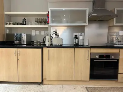 a kitchen with wooden cabinets and black counter tops at 109 on Oudehoek in Stellenbosch