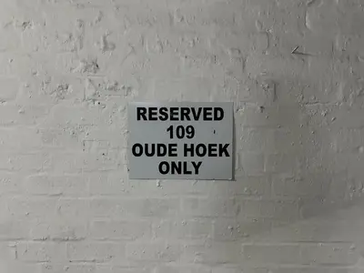 a white brick wall with a sign on it at 109 on Oudehoek in Stellenbosch