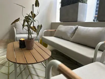 a living room with a couch and a table with a plant at 109 on Oudehoek in Stellenbosch