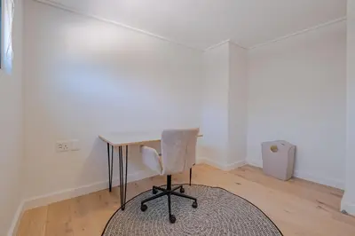 a desk in a room with a chair and a rug at Oakwood Hermanus in Hermanus