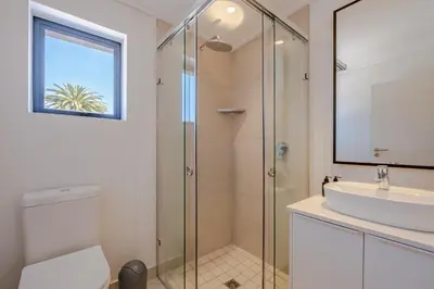 a bathroom with a glass shower and a sink at Oakwood Hermanus in Hermanus