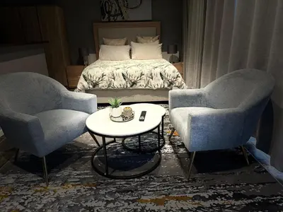 two chairs and a table in front of a bed at Apartment in Bellville - self-catering in Bellville