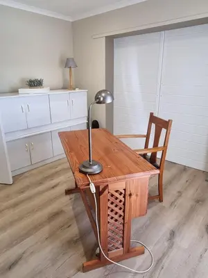 a desk with a lamp and a chair in a room at Peaceful, Cheerful, Family Friendly 3Bedroom house in Edgemead