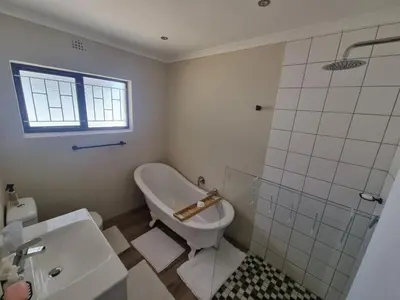 a bathroom with a tub and a toilet and a sink at Peaceful, Cheerful, Family Friendly 3Bedroom house in Edgemead