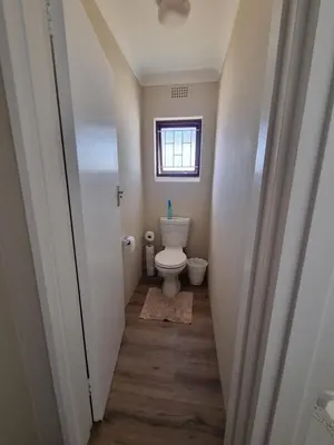 a small bathroom with a toilet and a window at Peaceful, Cheerful, Family Friendly 3Bedroom house in Edgemead