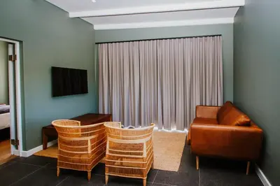 a living room with a chair and a couch at Mountain-View Stay, Aircon, WiFi, Parking in Somerset West