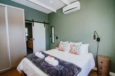 a bedroom with a bed with two towels on it at Mountain-View Stay, Aircon, WiFi, Parking in Somerset West