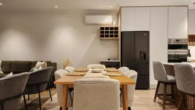 a kitchen and dining room with a table and chairs at De Waal Grandeur Apartment in Stellenbosch