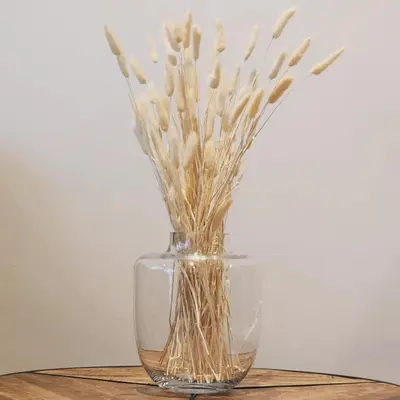 a glass vase with flowers in it on a table at De Waal Grandeur Apartment in Stellenbosch