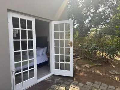 an open door leading to a balcony with a bed at The Dragonfly in Paarl