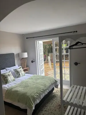 a bedroom with a bed and a sliding glass door at The Dragonfly in Paarl