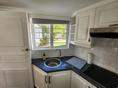 a small kitchen with a sink and a window at Cape Dutch haven in Durbanville