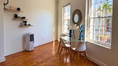 a dining room with a glass table and chairs at Obs Centre The Lookout in Cape Town