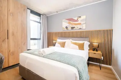 a bedroom with a large bed and a window at 318 Riverlands - Lux 1 bedroom Apartment in Cape Town