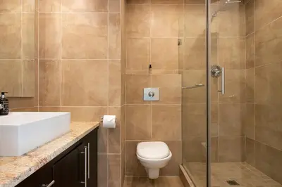 a bathroom with a shower and a toilet and a sink at Dolphin Beach C111 Sea -Table Mountain Views at Dolphin Beach in Cape Town