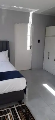 a bedroom with a bed and a room with a door at RoomIsGood in Cape Town