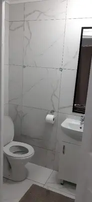 a white bathroom with a toilet and a sink at RoomIsGood in Cape Town