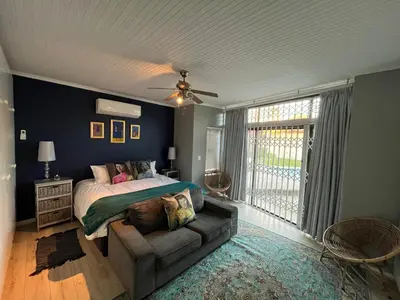 a bedroom with a bed and a couch in it at Queens Corner in Wellington